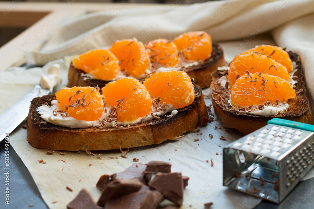 Delicious toast with sweet tangerine on black wood background Delicious toast with sweet tangerine on black wood background