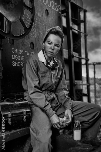 Tableau sur toile Vintage dirty female worker having her lunch break with a sandwich and a bottle
