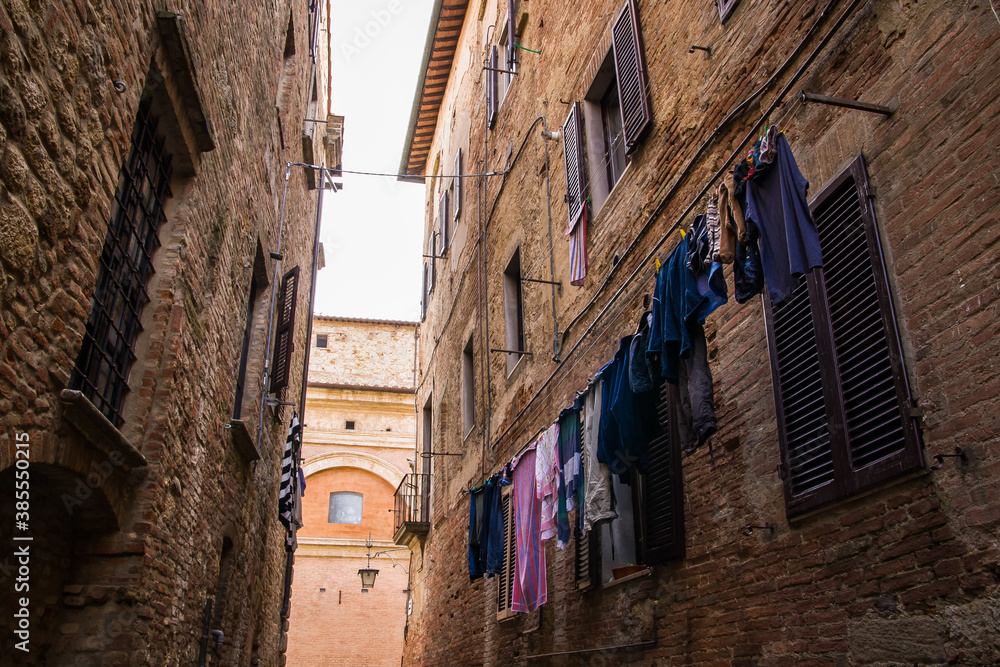 narrow street in the old town, clothes in the street, italy, tuscany