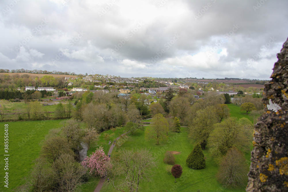 Park with many trees and houses in the background and with a very cloudy sky