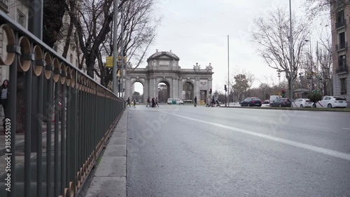 Scene On The Road In Madrid, Spain With The Famous Puerta De Alcala, A Neo-classical Gate In The Plaza de la Independencia, In The Background - sideways long shot photo