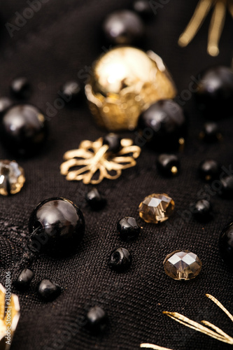 Embroidery composition of black beads and golden flowers on fabric