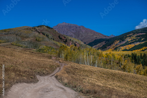 female trailrunner on mountain road in fall