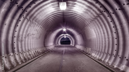 Large industrial stile illuminated tunnel with shadows on the walls