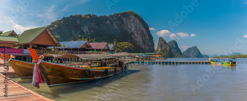 Traditional longtailed speed boats moored at the jetty of the settlement of Ko Panyi in Phang Nga Bay, Thailand