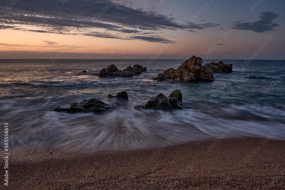 Sunrise with orange colors on the beach of Sant Pol de Mar (Barcelona)