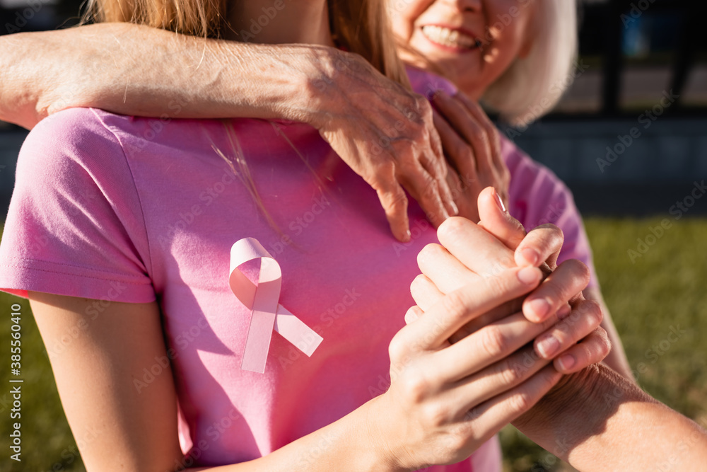 Fototapeta premium Selective focus of women embracing and holding hand outdoors