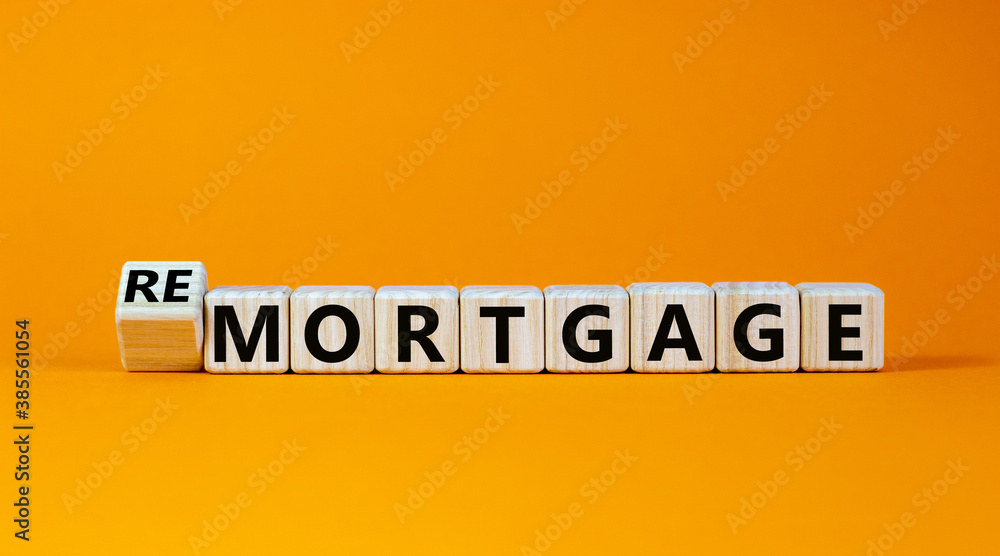 Turned a cube and changed the word 'remortgage' to 'mortgage' or vice versa. Beautiful orange background, copy space. Business concept. Turned a cube and changed the word 'remortgage' to 'mortgage' or vice versa. Beautiful orange background, copy space. Business concept.