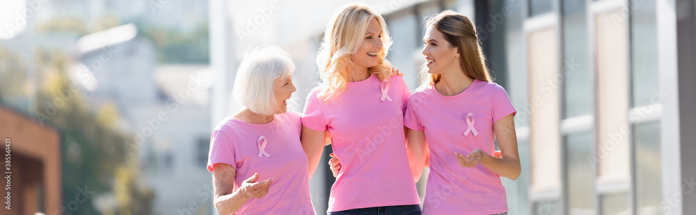 Panoramic shot of women with pink ribbons of breast cancer awareness outdoors Panoramic shot of women with pink ribbons of breast cancer awareness outdoors