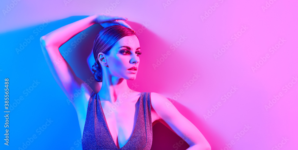 Woman in colorful neon light, make-up. Sexy Fashion girl, stylish hair, trendy makeup. Party disco neon style. Creative art beauty portrait, fashionable model, bright make up