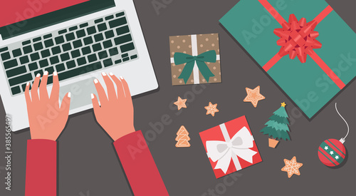 human hand using a laptop with presents, cookies, and Christmas tree, vector flat lay illustration