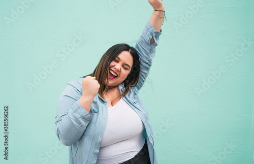 Wallpaper Mural Young plus size woman celebrating victory. Torontodigital.ca