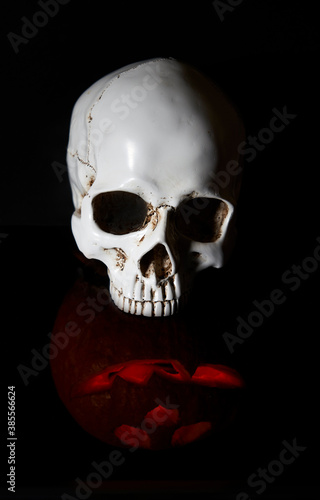 halloween 2020 and coronavirus. Happy halloween Carving. Halloween pumpkin head lantern on black background, with human skull. idea for halloween