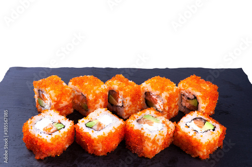 Sushi and roll set with tobiko caviar, avocado, and cheese. On a black backing.