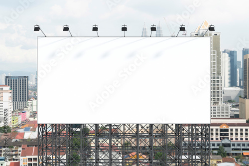 Blank white road billboard with KL cityscape background at day time. Street advertising poster, mock up, 3D rendering. Front view. The concept of marketing communication to promote or sell idea.