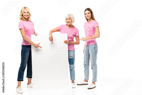 Women in pink t-shirts pointing at empty board on white background  concept of breast cancer