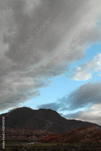View of the mountains, valley, sandstone and rocky formation under a dramatic sky with stormy clouds at sunset. 