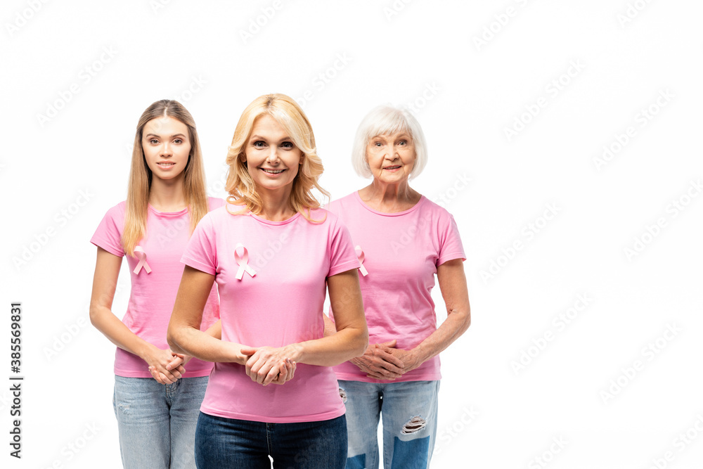 Obraz premium Concept of breast cancer awareness with women in pink t-shirts with ribbons isolated on white
