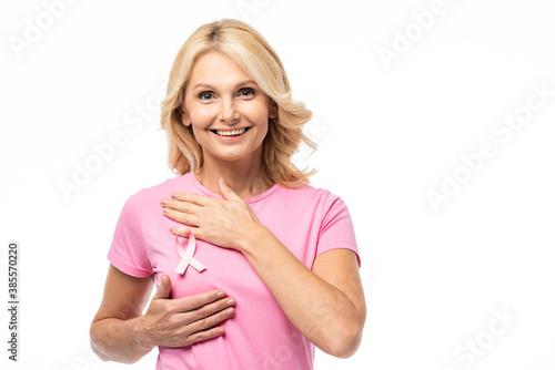 Obraz na plátně Blonde woman looking at camera while touching breast isolated on white, breast c