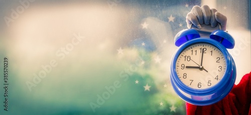 santa claus with alarm clock at christmas photo