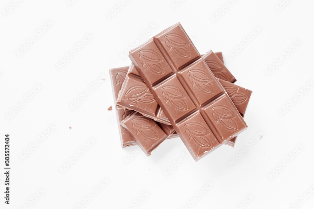 Milk chocolate pieces isolated on white background from top view, close up a chocolate bar isolated on white background