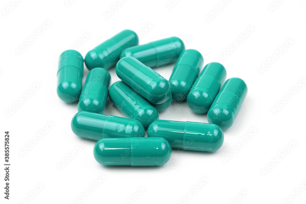 Green capsules on a white background. Green tablets in a shell close-up. Food additives, medications, sedatives. Green capsules on a white background. Green tablets in a shell close-up. Food additives, medications, sedatives.
