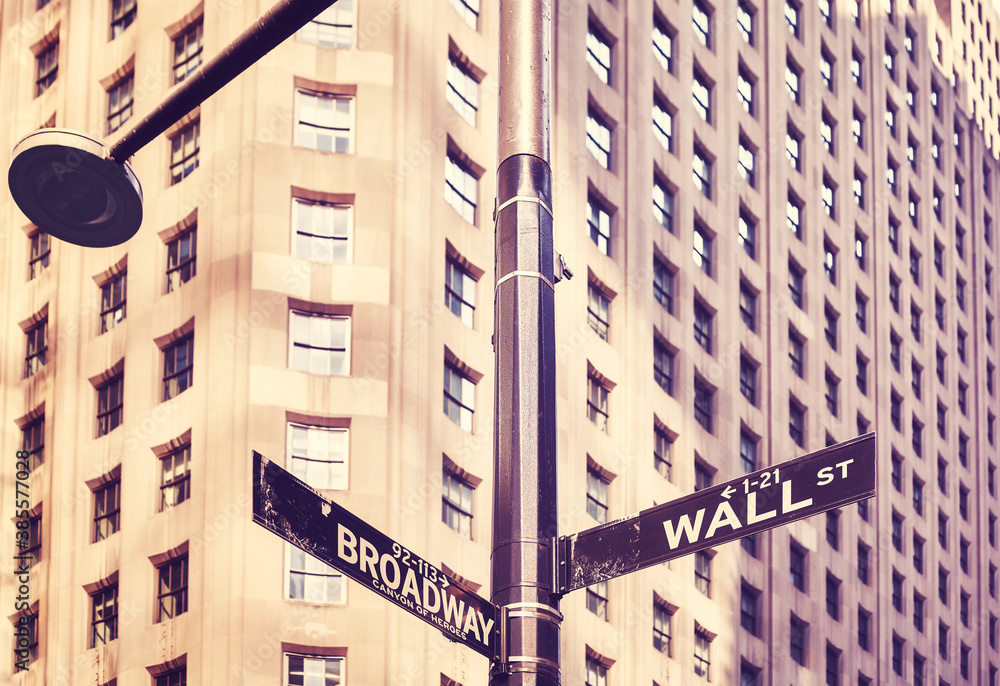 Naklejka premium Wall Street and Broadway street sign in Manhattan, color toning applied, selective focus, New York, USA.