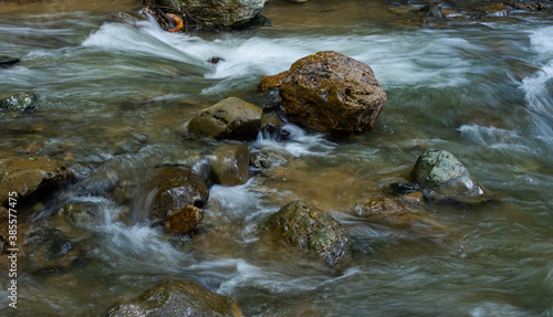 Blurry motion of water flows through the rocks in nature