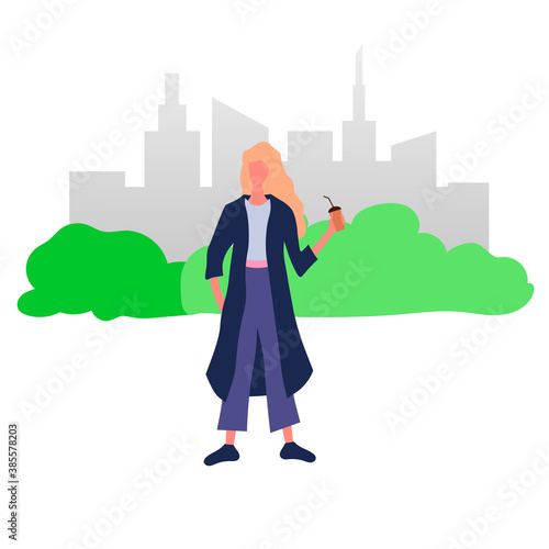 A woman with a coffee cup standing in a park.