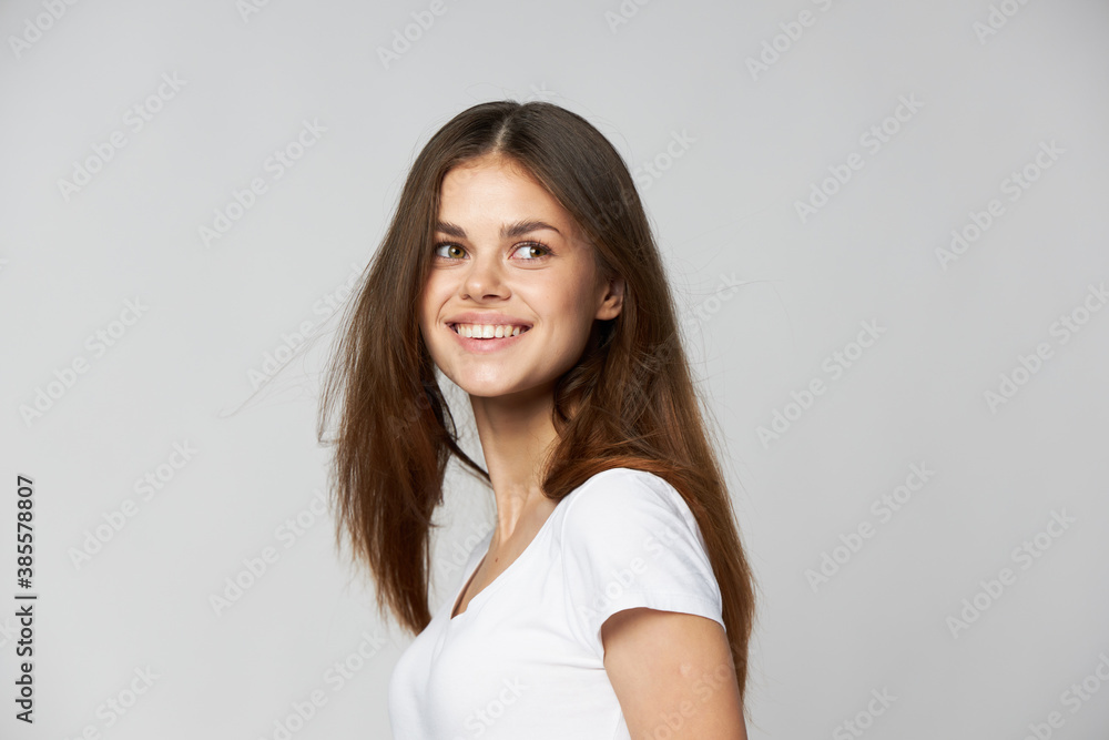 Happy woman smiling and looking to the side on a light background cropped view 