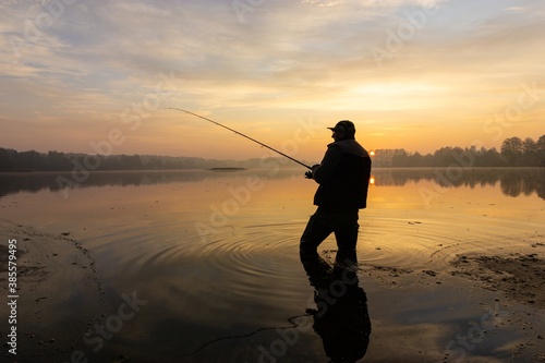 fisherman silhouette during cloudy sunrise
