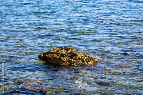 Large brown stone above the water. Clear sea water and rocky bottom © Лилия Люцко