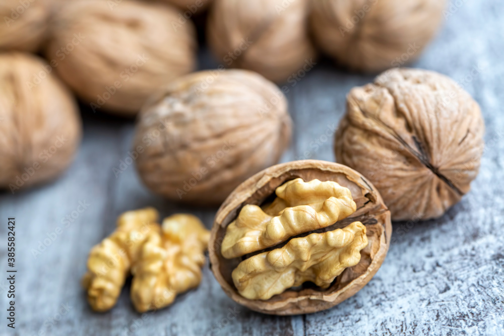 Ripe and raw whole big walnut kernel with thin shell on wooden rustic backdrop. Healthy nut food for brain. Fresh walnuts background concept Ripe and raw whole big walnut kernel with thin shell on wooden rustic backdrop. Healthy nut food for brain. Fresh walnuts background concept
