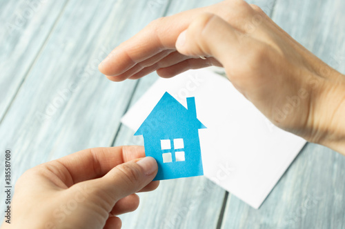 Sales manager or real estate agent prepares to hand over the keys and the house together with the insurance to the customer,