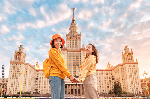 Two female friends students on the background of the building of Moscow University. Education, tourism and holiday concept