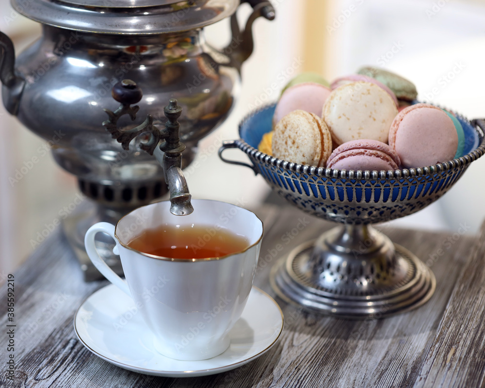 a cup of tea, macaroons and a samovar on the table a cup of tea, macaroons and a samovar on the table