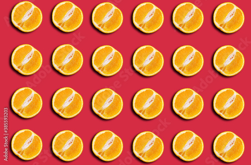 Pattern of fresh orange halves on a red background with a shadow.