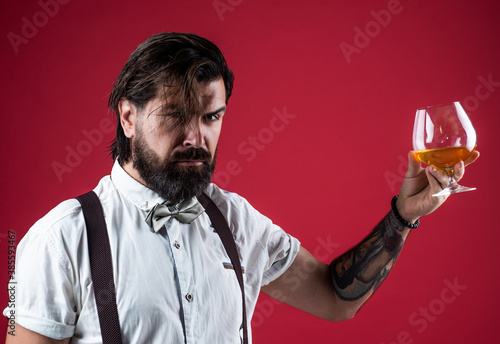 try this. whiskey and scotch. old fashioned bearded barman. retro man in bow tie relaxing with alcohol. confident elegant bartender in classical wear drinking brandy. masculinity and charisma