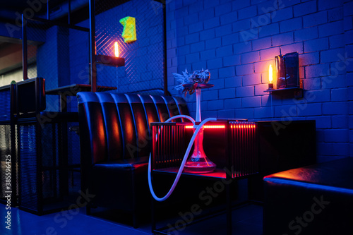 Hookah with hot coals served in pineapple. Concept of the original hookah serving. Hookah interior in neon light. photo