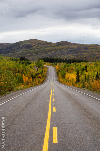 View of Scenic Road surrounded by Mountains and Trees on a Fall Day in Canadian Nature. Klondike Highway, Yukon, Canada.