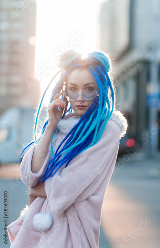 Glamorous girl with dreadlocks on the street near the business center