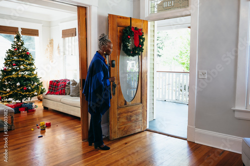 Senior woman welcoming visitors to home for Christmas photo