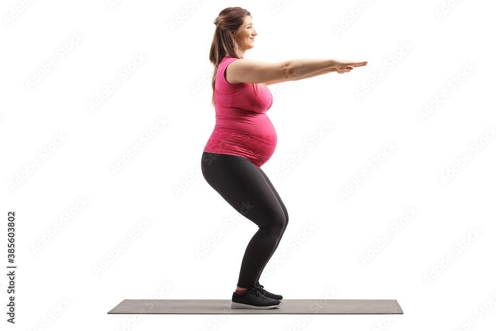 Full length profile shot of a pregnant woman exercising squats Full length profile shot of a pregnant woman exercising squats