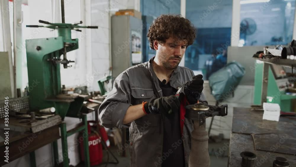 Auto mechanic working underneath car lifting machine at the garage. Auto repair shop, Car service, repair. Auto mechanic working underneath car lifting machine at the garage. Auto repair shop, Car service, repair.