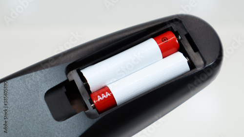 Εκτύπωση καμβά Black TV remote control with AAA alkaline batteries in red and white on a white background