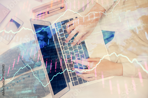 Double exposure of woman hands working on computer and forex graph hologram drawing. Top View. Financial analysis concept.