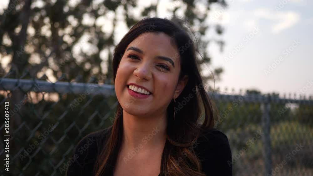 A beautiful adult hispanic woman laughing with a friend or date on a walk through the park at sunset SLOW MOTION. A beautiful adult hispanic woman laughing with a friend or date on a walk through the park at sunset SLOW MOTION.