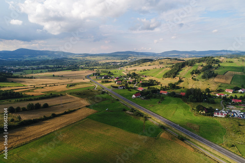 Hills and mountains among meadows. The meadows crossed by lines of trees constitute the landscape of the vicinity of Kamienna Góra in Poland