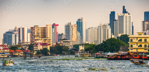 Obraz na płótnie City Skyline as Seen from the Tourist Boat on Chao Phraya River at Sunset in Bangkok, Thailand w salonie