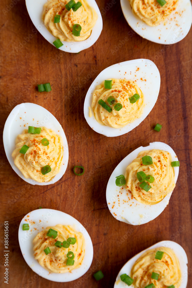 Homemade Deviled Eggs with Chives on a rustic wooden board, overhead view. Flat lay, top view, from above. Homemade Deviled Eggs with Chives on a rustic wooden board, overhead view. Flat lay, top view, from above.